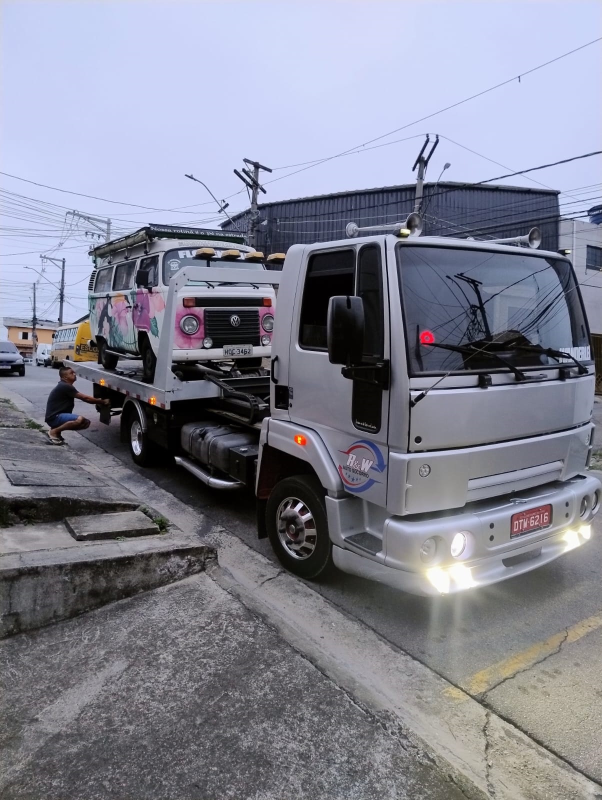 Caminhão guincho branco da empresa em atendimento na estrada