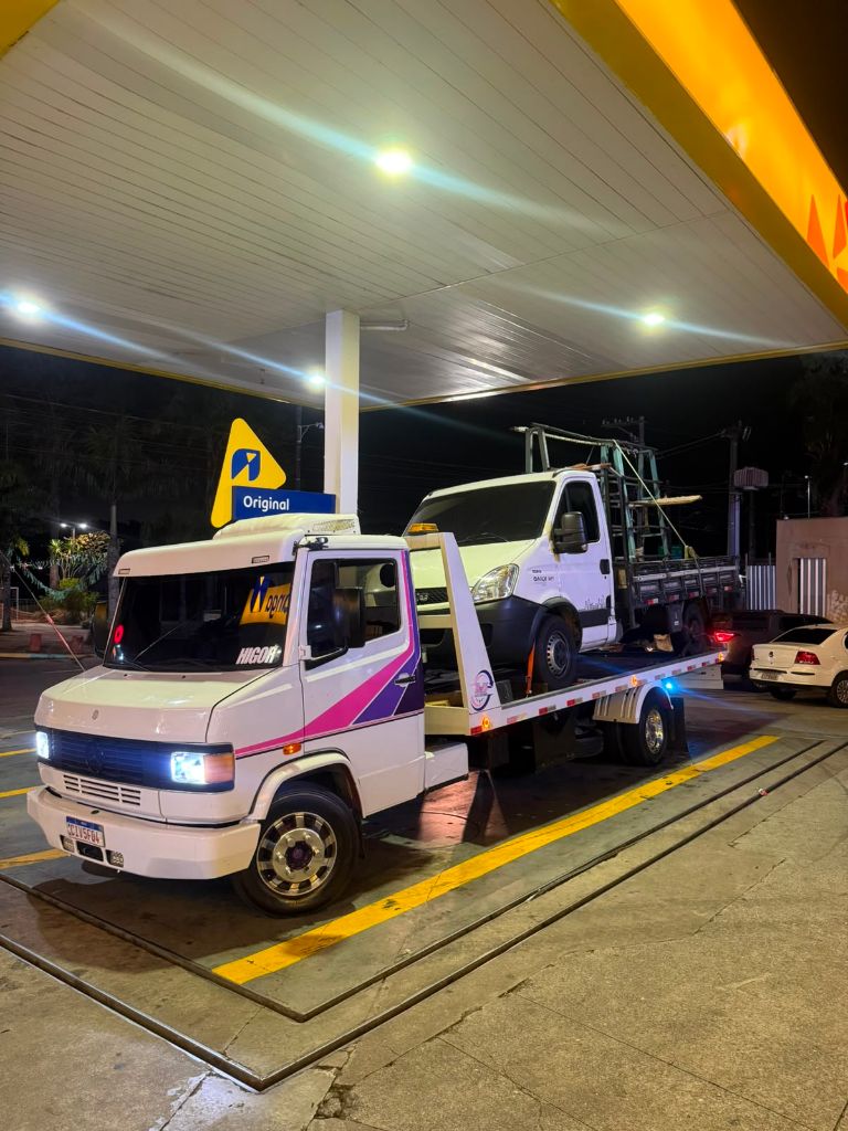 Guincho branco transportando van durante atendimento noturno
